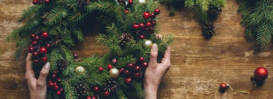 A person is holding a holiday wreath