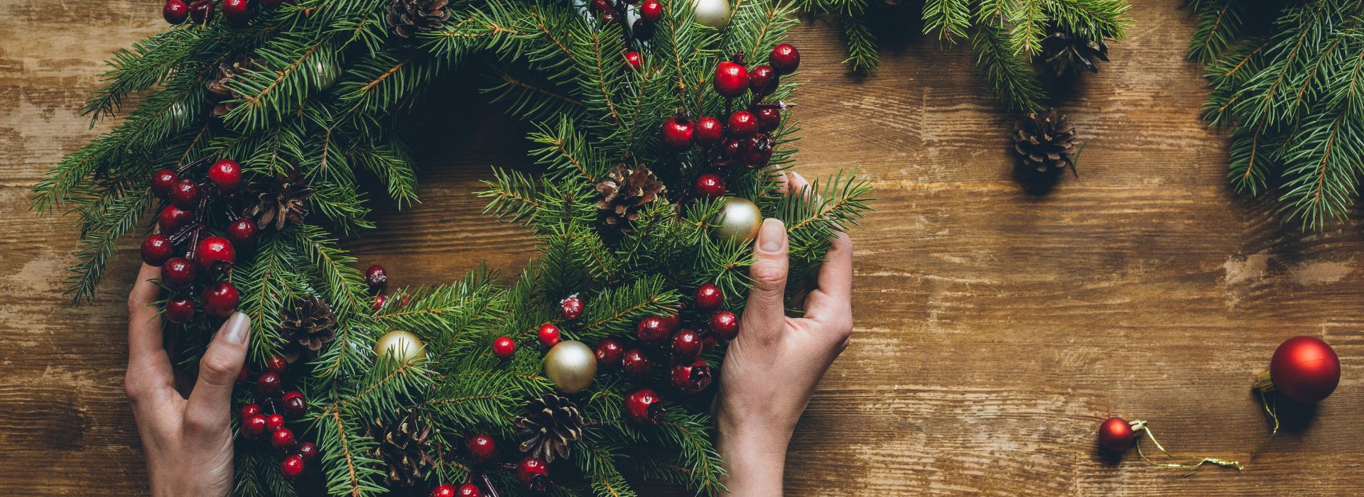 A person is holding a holiday wreath