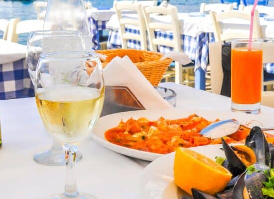 Plates of seafood with wine served by the water