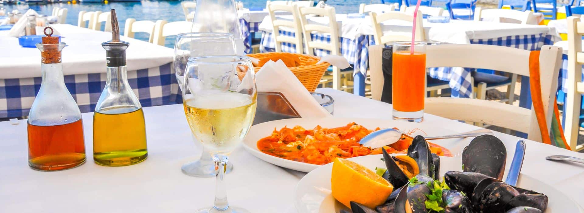 Plates of seafood with wine served by the water