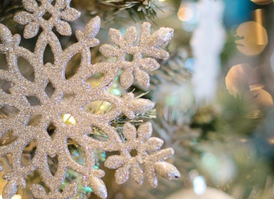 A silver glittered snowflake ornament on a Christmas tree