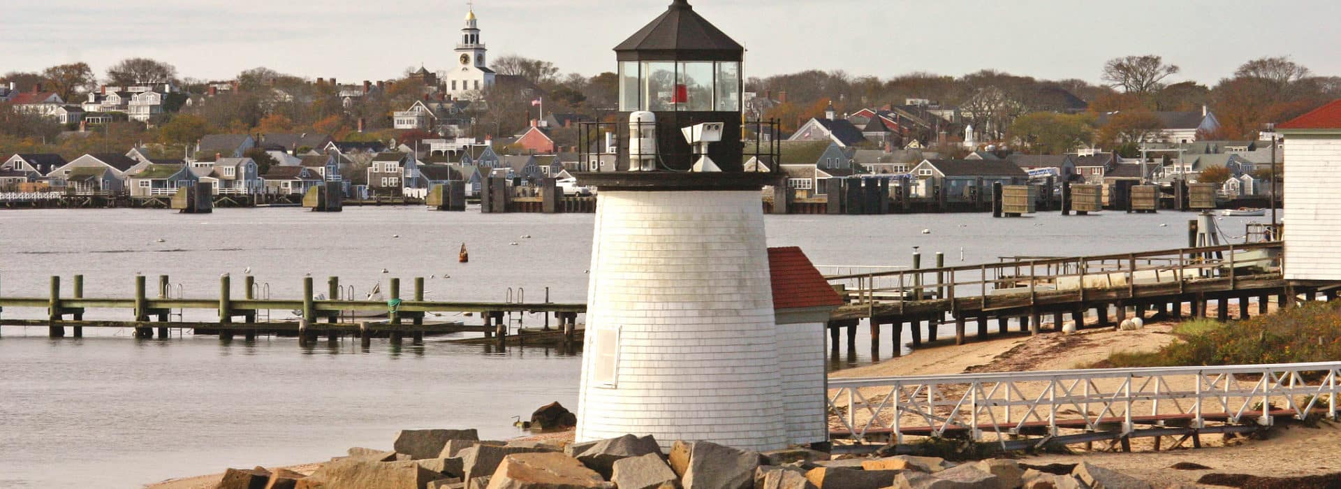 Lighthouse near a pier and water in the fall