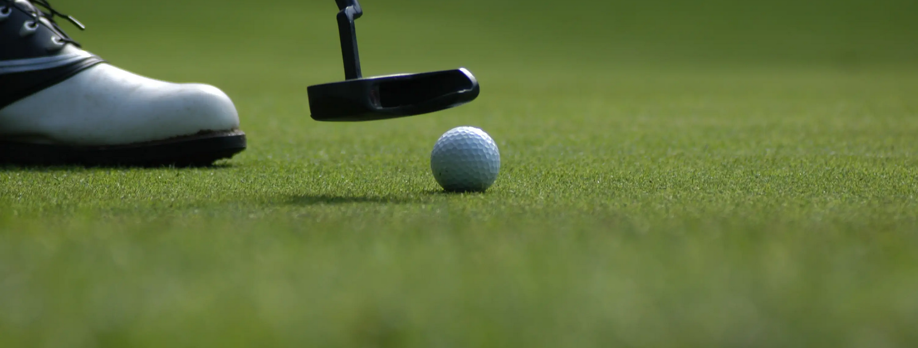 View of golfer's foot and club preparing to hit a ball