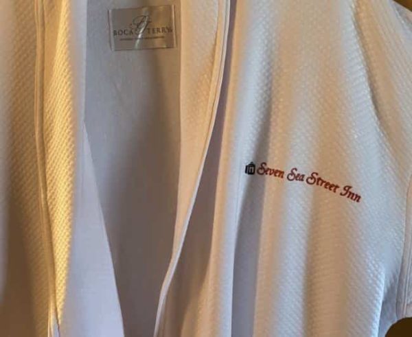 White robe with embroidered Seven Sea Street text in red