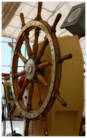 The wooden wheel of a sail boat